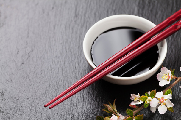 Pałeczki japońskie sushi, sos sojowy miski i sakura kwiat - Zdjęcie, obraz