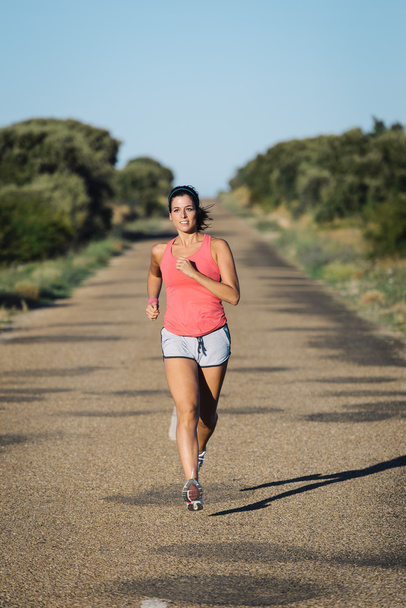 Woman running on country asphalt road - Photo, Image