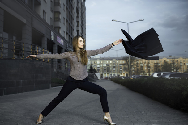 jeune fille pratiquant le yoga dans la rue, vêtue d'un costume d'affaires
 - Photo, image