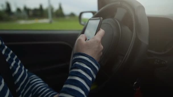 Female driving car and texting sms message on smartphone - Séquence, vidéo