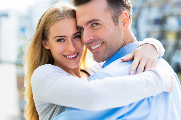 couple smiling outdoors and embracing - Fotó, kép