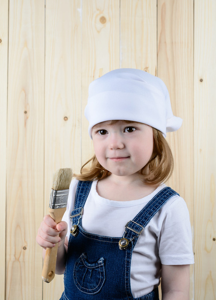 Menina posando com uma escova na parede de madeira
 - Foto, Imagem