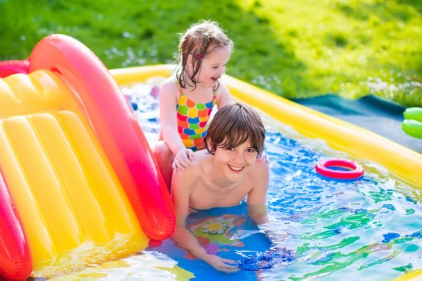 Niños jugando en piscina inflable
 - Foto, imagen