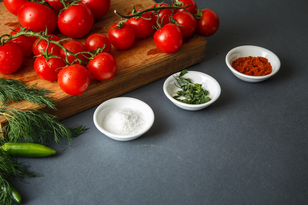 Tomatoes with green pappers and herbs on gray - Фото, изображение
