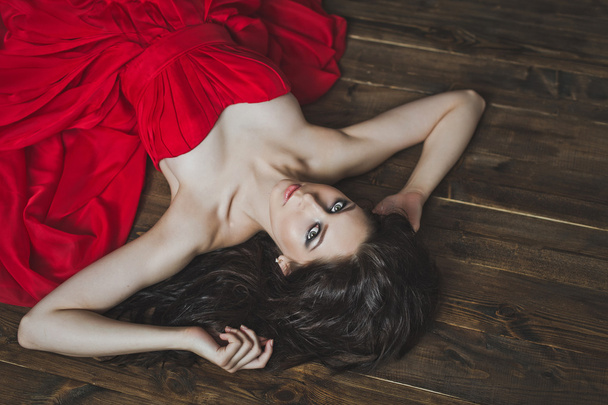 The girl in the red dress lying on the floor 6003. - Fotoğraf, Görsel