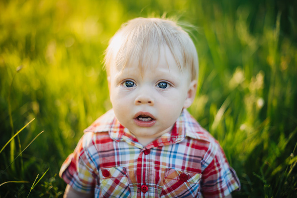Enfant frustré sur un fond d'herbe
 - Photo, image
