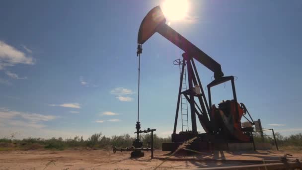 Industrial jack pump working on oil field over the sun - Footage, Video