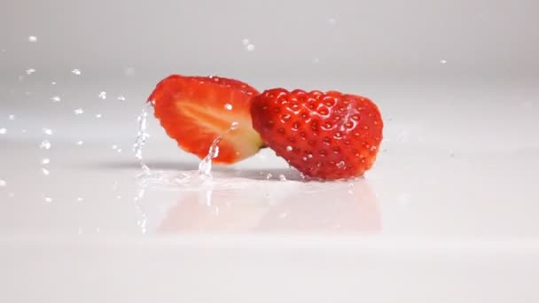 Sliced strawberry fall on white surface - Footage, Video