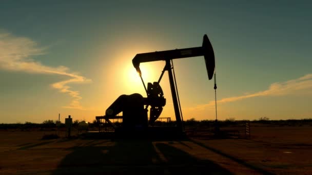 Jack przemysłowe pompy platformy pompowania ropy naftowej na zachód słońca - Materiał filmowy, wideo