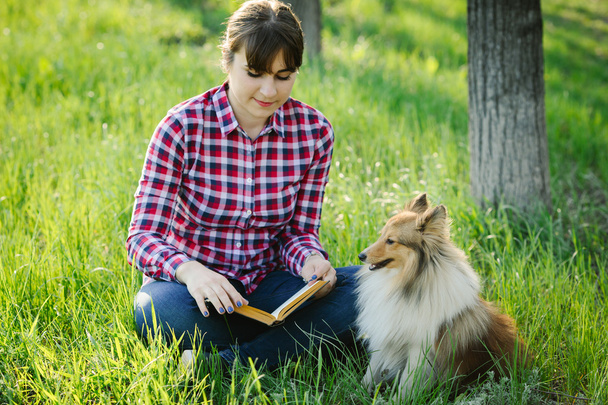 Student girl learning in nature with dog - Zdjęcie, obraz