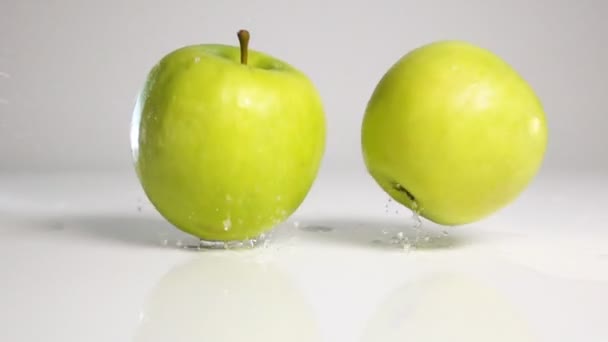 Duas maçãs caem na superfície branca
 - Filmagem, Vídeo