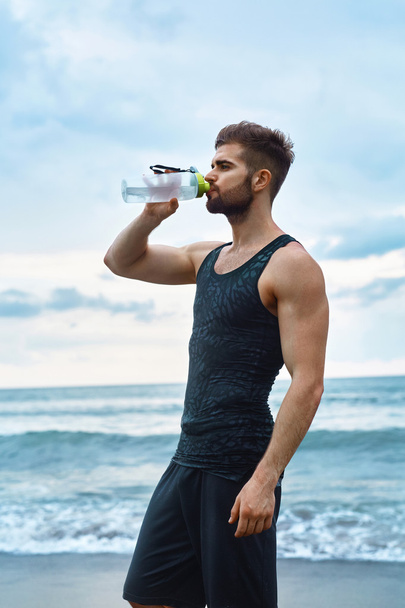 Man Drinking Refreshing Water After Workout At Beach. Drink - Foto, Imagem