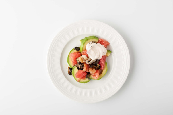 Salad with avocado and seafood on a relief plate - Фото, зображення