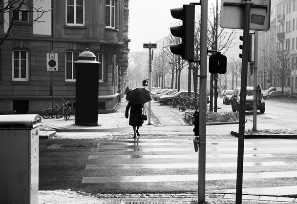Vieja con paraguas cruzando la calle
 - Foto, imagen