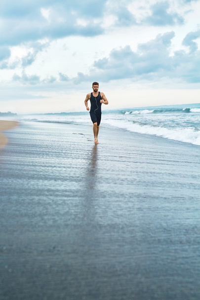 Fitness Man Running On Beach. Runner Jogging During Outdoor Workout - Fotografie, Obrázek