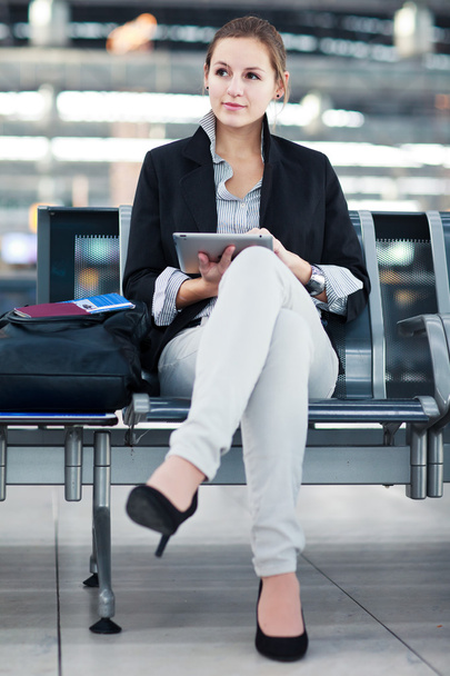 Young female passenger at the airport, using her tablet computer - Foto, immagini