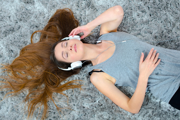 Laying on the floor with her headphones - Foto, immagini