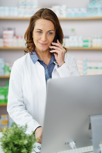 Female pharmacist in lab coat taking orders - Foto, imagen