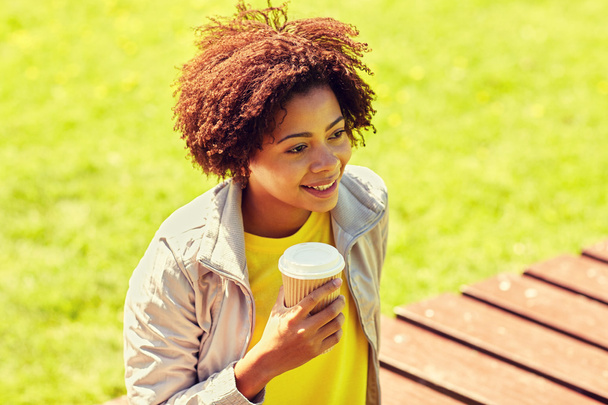 uśmiechnięta kobieta picie kawy na zewnątrz - Zdjęcie, obraz