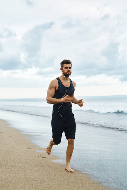 Juokseva mies lenkkeilee rannalla kuntoilun aikana ulkona. Urheilu
 - Valokuva, kuva