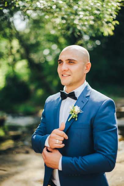 Bräutigam im blauen Anzug knöpft Manschetten - Foto, Bild