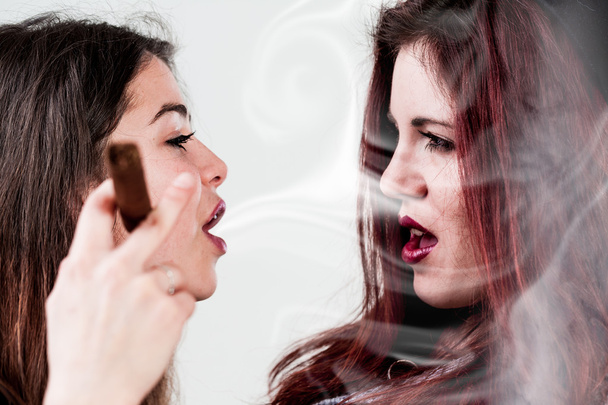 eine Frau bläst der anderen Rauch ins Gesicht - Foto, Bild