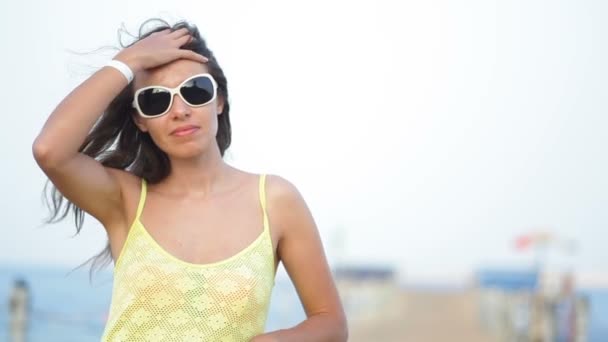 femme en lunettes de soleil posant sur le ponton près de la mer
 - Séquence, vidéo