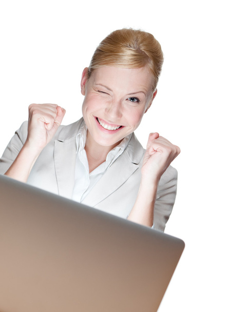 Heureuse jeune femme d'affaires assise à un bureau avec ordinateur portable
 - Photo, image