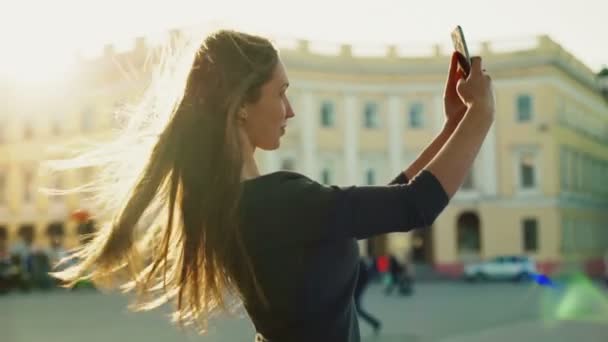 smiling young woman making selfie in the street slow motion - Metraje, vídeo