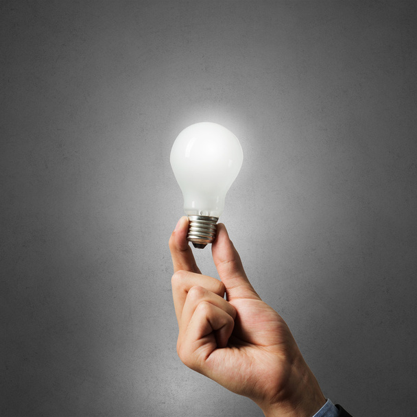 Glowing bulb in hand - 写真・画像