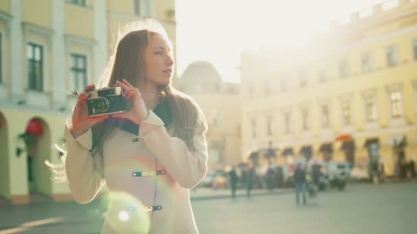 young female taking pictures of a city with an old camera slow motion - Imágenes, Vídeo
