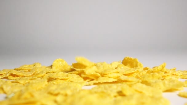 Płatki kukurydziane spadnie na białej powierzchni - Materiał filmowy, wideo