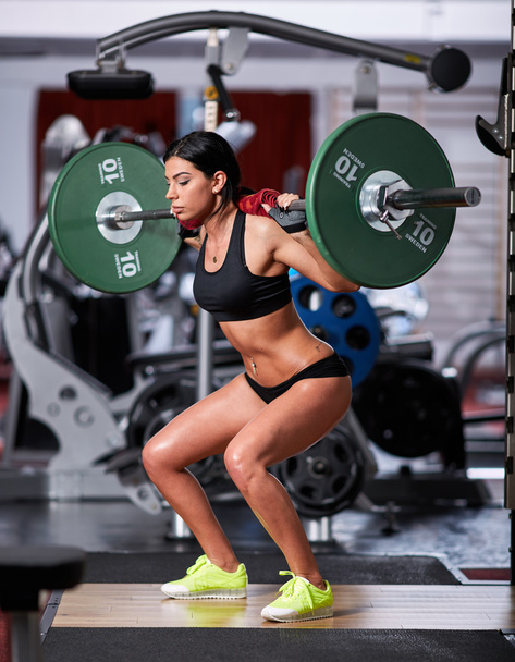 woman doing squats with barbell  - Фото, зображення