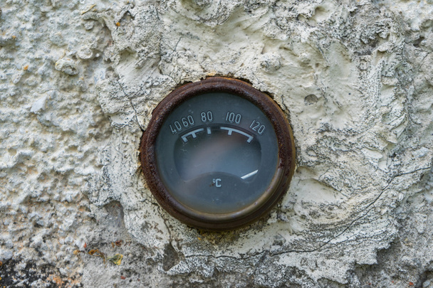 Παλιό σκουριασμένο θερμόμετρο εκλεκτής ποιότητας ενσωματωμένο σε πέτρα ή ροκ τοίχο. - Φωτογραφία, εικόνα