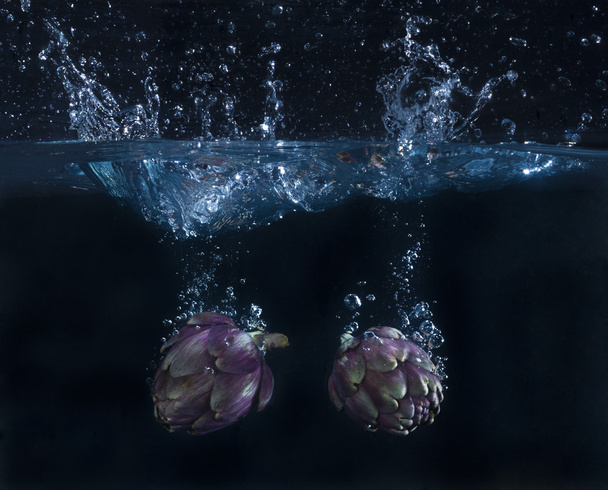 due carciofi tuffati in acqua - Photo, Image