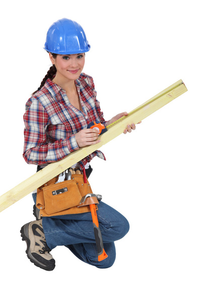 Female carpenter measuring timber - 写真・画像