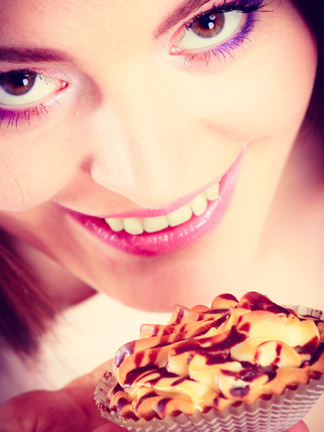Smiling woman holds cake in hand - Foto, imagen
