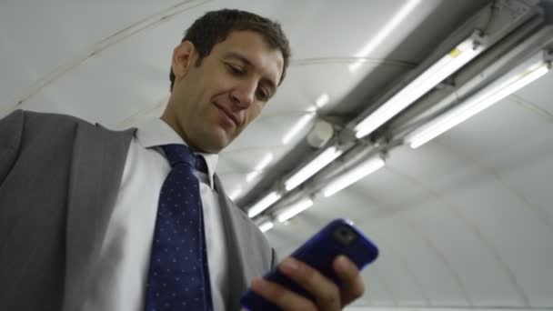 businessman with smartphone going down escalator - Πλάνα, βίντεο