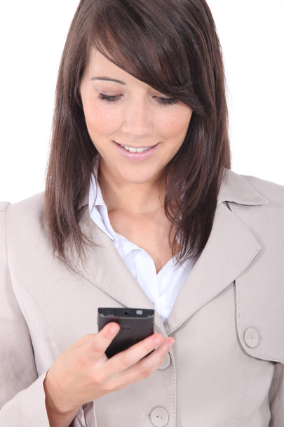 Young brunette sending message with mobile phone - Zdjęcie, obraz