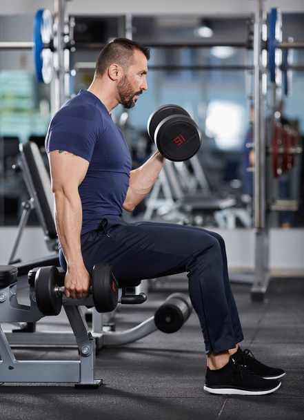 Athletic man doing biceps curl  - Photo, image