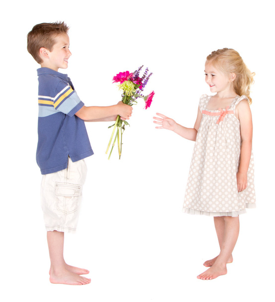 Little boy handing flowers to little girl - 写真・画像