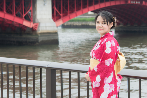 Азиатка в красном кимоно идёт по мосту
 - Фото, изображение