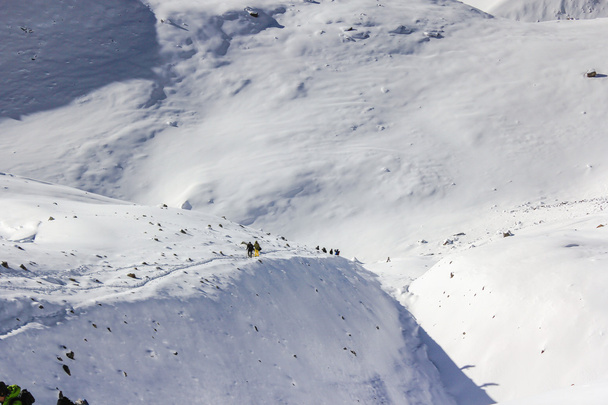 Une équipe d'alpinistes se dirige vers le sommet avec neige et vent
 - Photo, image