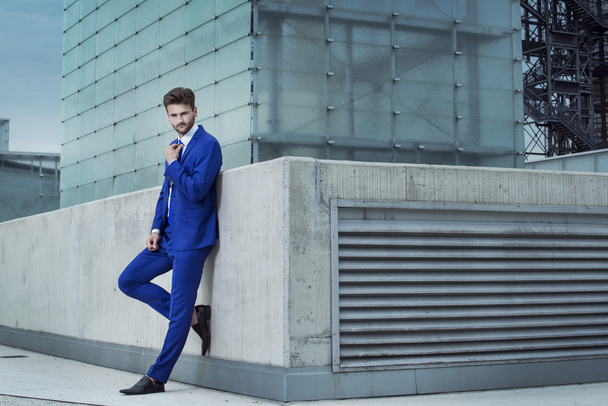 Hombre guapo en un traje azul en el fondo de la ciudad
 - Foto, imagen
