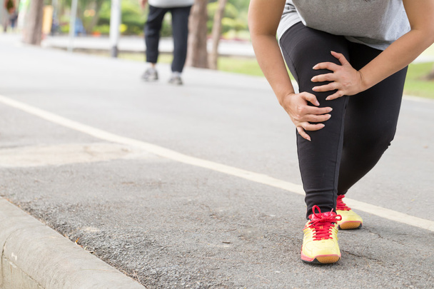 Sportverletzung. Frau mit Schmerzen im Knie beim Joggen - Foto, Bild