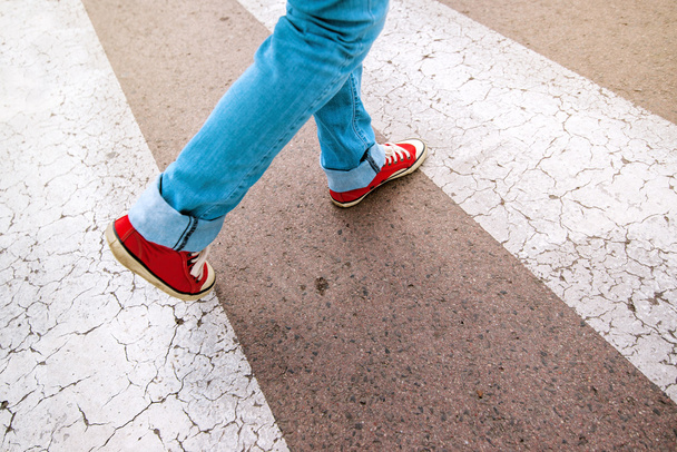 Young teenage person walking over pedestrian zebra crosswalk - Fotoğraf, Görsel