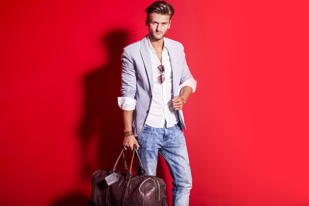 Model man in red with luggage. - Photo, Image