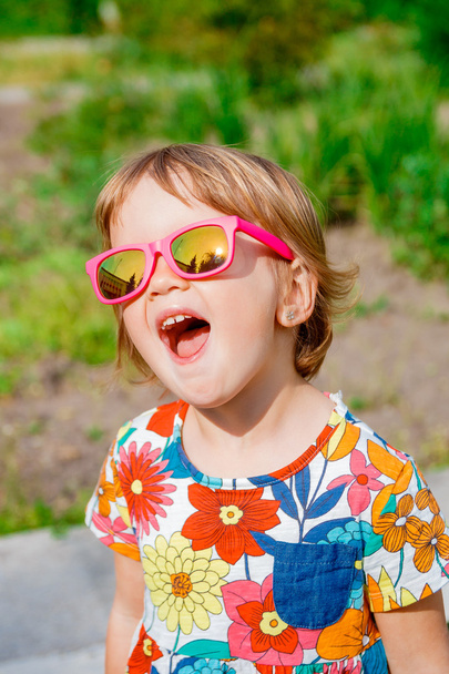 Menina bonito feliz em óculos de sol rosa
 - Foto, Imagem