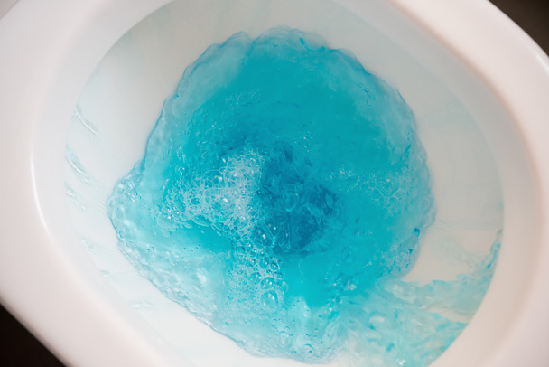 flushing a closestool with blue water - Zdjęcie, obraz