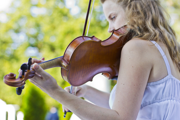 屋外のバイオリンを弾いている女の子。結婚式のための音楽家。オープン空の下でヴァイオリン - 写真・画像